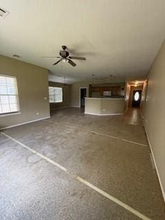 1210 Apache Dr, Bentonville, AR 72712 - unfurnished living room featuring healthy amount of natural light, ceiling fan, and baseboards