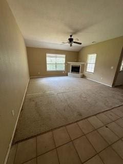 1210 Apache Dr, Bentonville, AR 72712 - unfurnished living room with healthy amount of natural light, a ceiling fan, carpet flooring, and baseboards