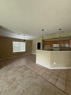 1210 Apache Dr, Bentonville, AR 72712 - kitchen featuring tile patterned floors, white microwave, brown cabinetry, and open floor plan