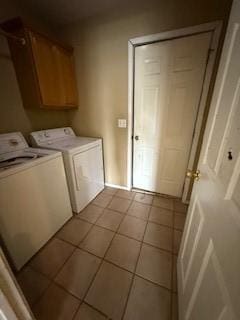 1210 Apache Dr, Bentonville, AR 72712 - washroom featuring washer and dryer, light tile patterned floors, and cabinet space