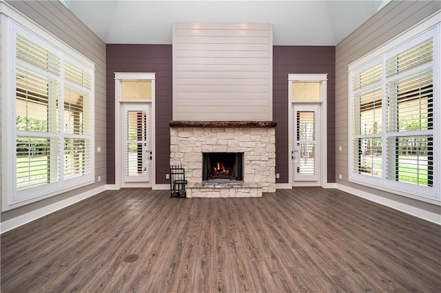 19643 Indigo Dr, Rogers, AR 72756 - unfurnished living room with lofted ceiling, dark wood-style flooring, plenty of natural light, a fireplace, and baseboards