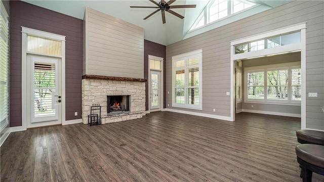 19643 Indigo Dr, Rogers, AR 72756 - unfurnished living room with dark wood-style floors, ceiling fan, a fireplace, wooden walls, and high vaulted ceiling