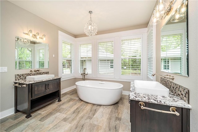 19643 Indigo Dr, Rogers, AR 72756 - bathroom featuring a chandelier, a freestanding tub, plenty of natural light, and two vanities