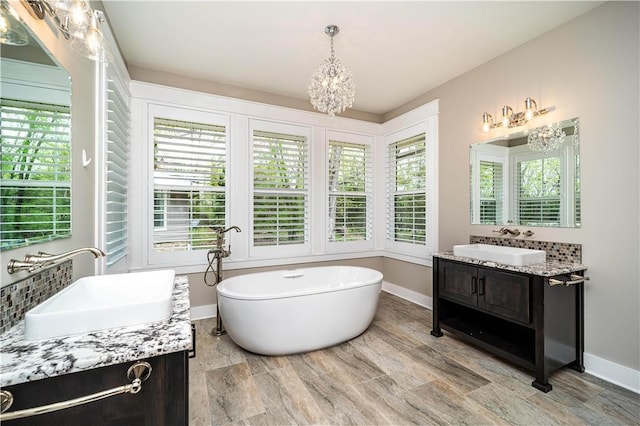 19643 Indigo Dr, Rogers, AR 72756 - bathroom featuring vanity, a soaking tub, a chandelier, and plenty of natural light