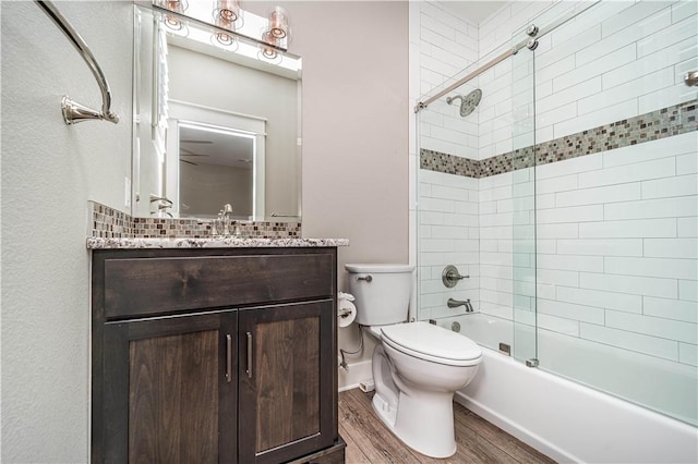 19643 Indigo Dr, Rogers, AR 72756 - full bathroom featuring wood finished floors, bath / shower combo with glass door, vanity, and toilet