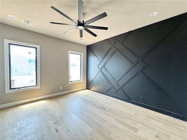 6702 SW Brilliance Ter, Bentonville, AR 72713 - empty room featuring wood finished floors, a ceiling fan, and baseboards