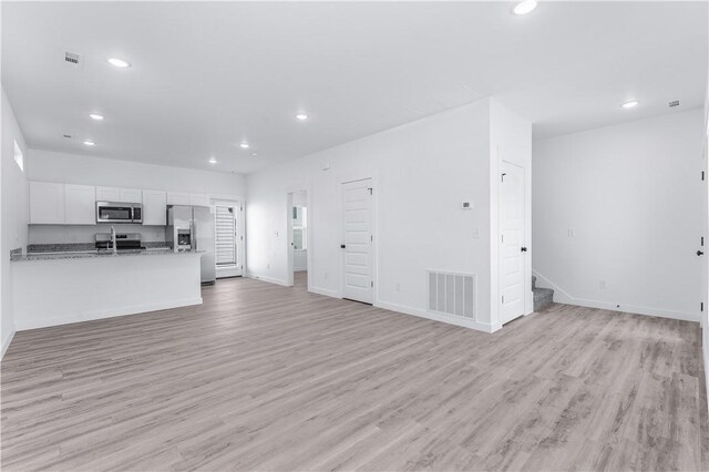 841 States Ave, Bentonville, AR 72713 - unfurnished living room featuring recessed lighting, light wood-style flooring, baseboards, and stairway