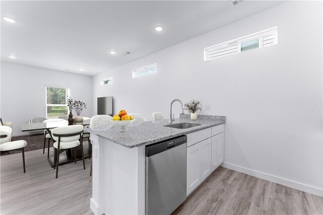841 States Ave, Bentonville, AR 72713 - kitchen with stainless steel dishwasher, a sink, white cabinetry, light wood-type flooring, and healthy amount of natural light