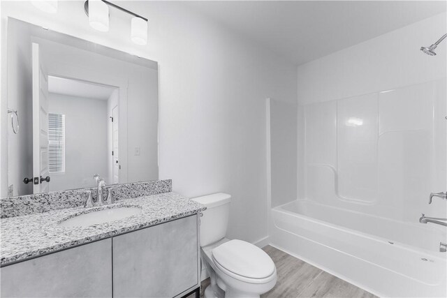 841 States Ave, Bentonville, AR 72713 - bathroom featuring toilet, vanity, wood finished floors, bathing tub / shower combination, and baseboards