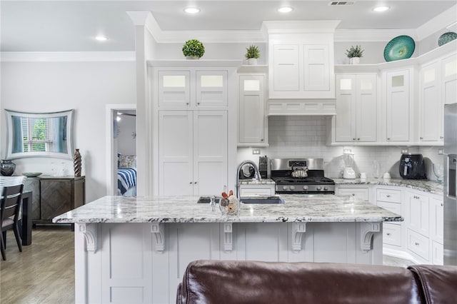 531 Chaparral St, Centerton, AR 72719 - kitchen featuring stainless steel appliances, ornamental molding, white cabinets, a kitchen breakfast bar, and a sink