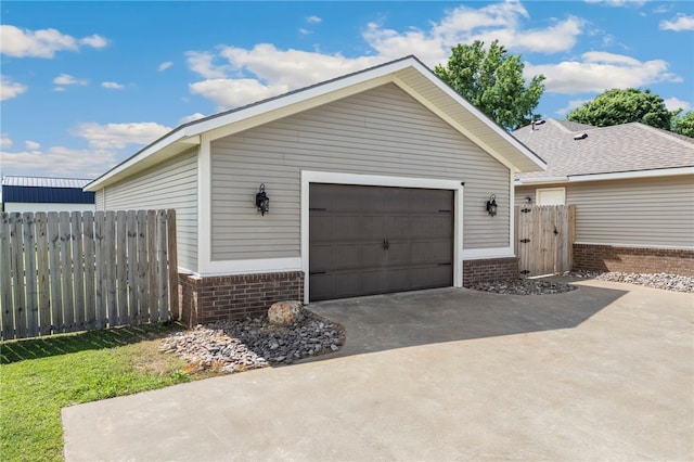6108 SW Lee Ln, Bentonville, AR 72713 - view of property exterior featuring brick siding, concrete driveway, and a gate
