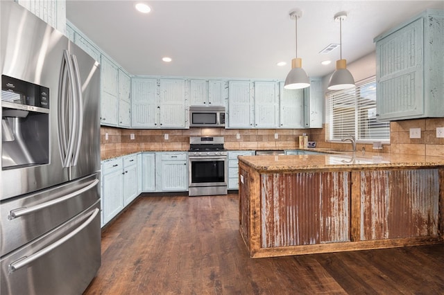 6108 SW Lee Ln, Bentonville, AR 72713 - kitchen featuring appliances with stainless steel finishes, a sink, tasteful backsplash, light stone countertops, and recessed lighting