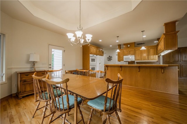 18 Cheviot Ln, Bella Vista, AR 72715 - dining space with light wood-type flooring, a chandelier, recessed lighting, and a raised ceiling
