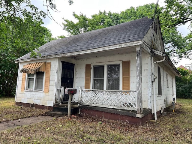 106 E Main St, Ozark, AR 72949 - shotgun-style home with roof with shingles and a porch