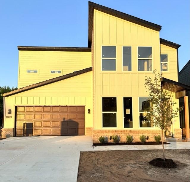 1209 SW Journey Ln, Bentonville, AR 72713 - contemporary home with board and batten siding, concrete driveway, and brick siding