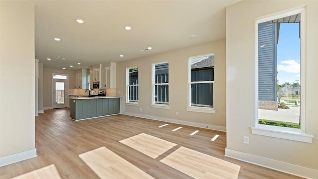 1209 SW Journey Ln, Bentonville, AR 72713 - unfurnished living room with light wood-type flooring and recessed lighting