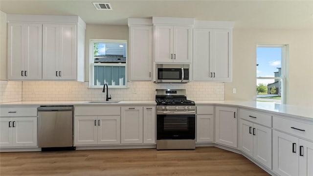 1209 SW Journey Ln, Bentonville, AR 72713 - kitchen with appliances with stainless steel finishes, white cabinetry, and tasteful backsplash