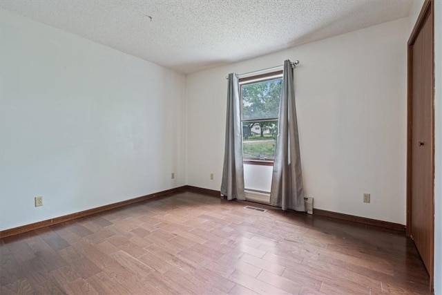 326 Hillcrest Rd, Eureka Springs, AR 72631 - empty room featuring a textured ceiling, light wood-style flooring, baseboards, and a baseboard heating unit