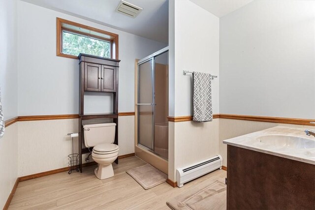 326 Hillcrest Rd, Eureka Springs, AR 72631 - bathroom with a baseboard heating unit, toilet, wood finished floors, an enclosed shower, and vanity