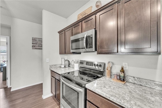 944 Maddy St, Elkins, AR 72727 - kitchen featuring appliances with stainless steel finishes, wood finished floors, dark brown cabinets, and light stone counters