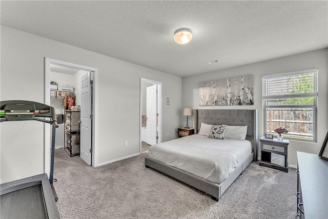 944 Maddy St, Elkins, AR 72727 - carpeted bedroom with a walk in closet, a textured ceiling, ensuite bathroom, and a closet