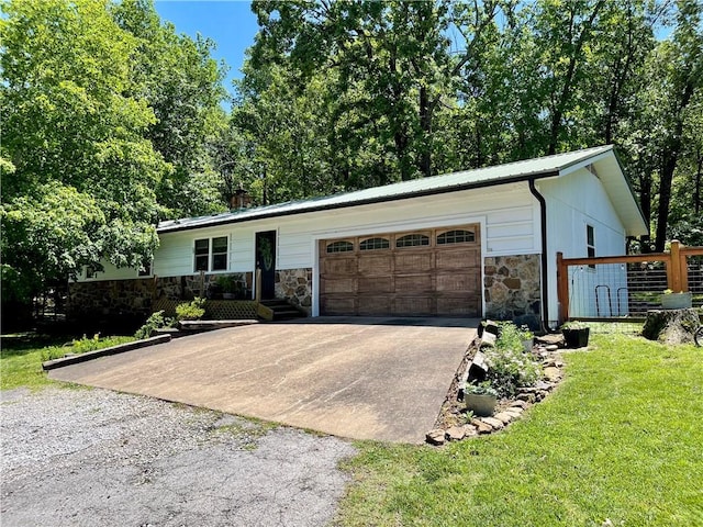 900 Dogwood St, Huntsville, AR 72740 - ranch-style house featuring stone siding, concrete driveway, an attached garage, a front yard, and a metal roof