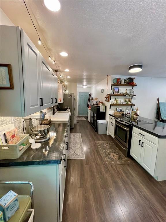 900 Dogwood St, Huntsville, AR 72740 - kitchen with stainless steel appliances, dark wood-type flooring, dark countertops, a textured ceiling, and white cabinets