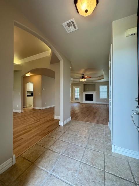 108 Hoss St, Centerton, AR 72719 - unfurnished living room featuring arched walkways, a ceiling fan, wood finished floors, baseboards, and ornamental molding