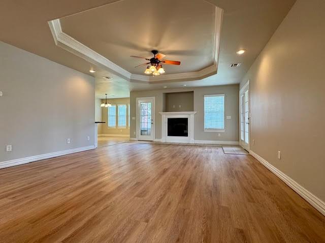 108 Hoss St, Centerton, AR 72719 - unfurnished living room with a tray ceiling, light wood finished floors, ceiling fan, crown molding, and baseboards