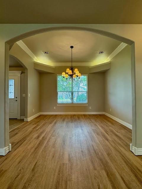108 Hoss St, Centerton, AR 72719 - unfurnished room featuring ornamental molding, arched walkways, wood finished floors, baseboards, and a chandelier