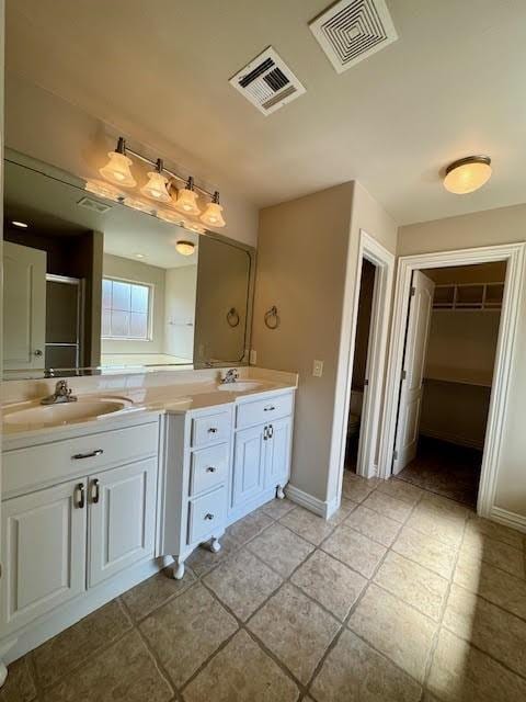 108 Hoss St, Centerton, AR 72719 - bathroom featuring double vanity, a spacious closet, baseboards, and tile patterned flooring