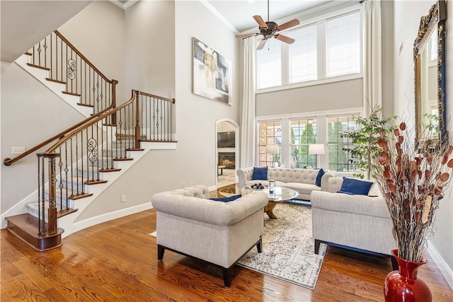 5304 S Promontory Ct, Rogers, AR 72758 - living area featuring a towering ceiling, wood finished floors, ceiling fan, stairs, and ornamental molding