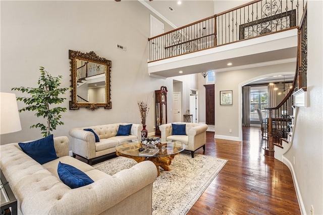 5304 S Promontory Ct, Rogers, AR 72758 - living area featuring arched walkways, stairway, wood finished floors, crown molding, and a high ceiling