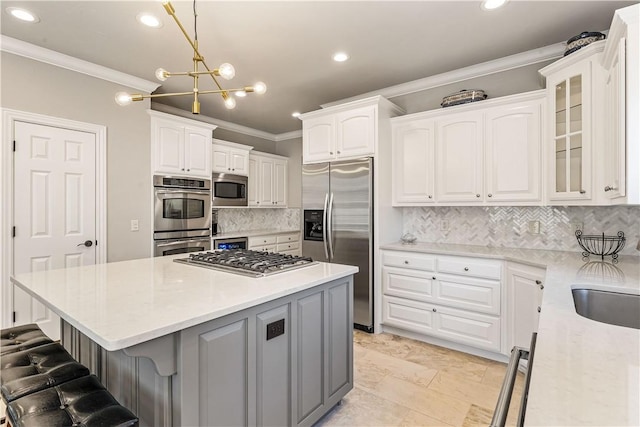 5304 S Promontory Ct, Rogers, AR 72758 - kitchen with appliances with stainless steel finishes, crown molding, a kitchen island, a breakfast bar area, and decorative backsplash