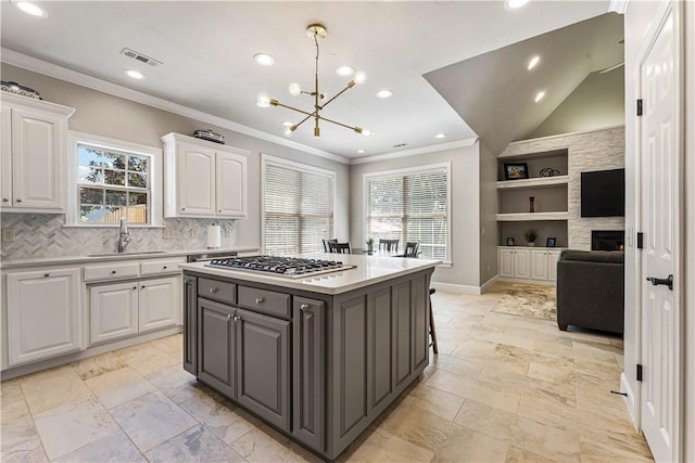 5304 S Promontory Ct, Rogers, AR 72758 - kitchen featuring stainless steel gas cooktop, white cabinets, a chandelier, recessed lighting, and light countertops