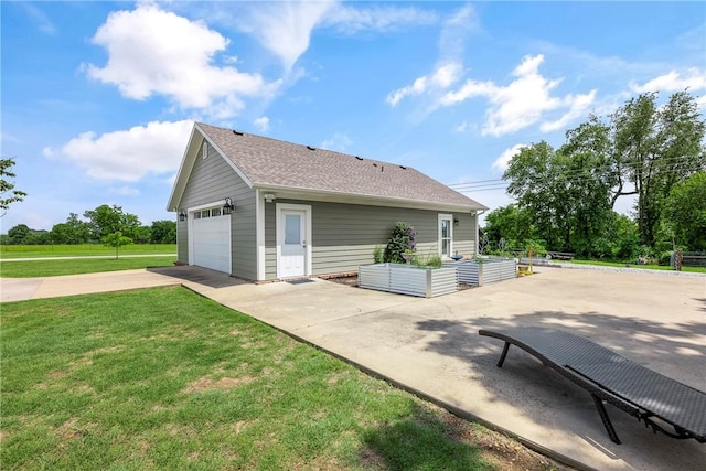 5500 SW Gunstock Rd, Bentonville, AR 72713 - back of property featuring concrete driveway, a vegetable garden, a garage, a yard, and roof with shingles
