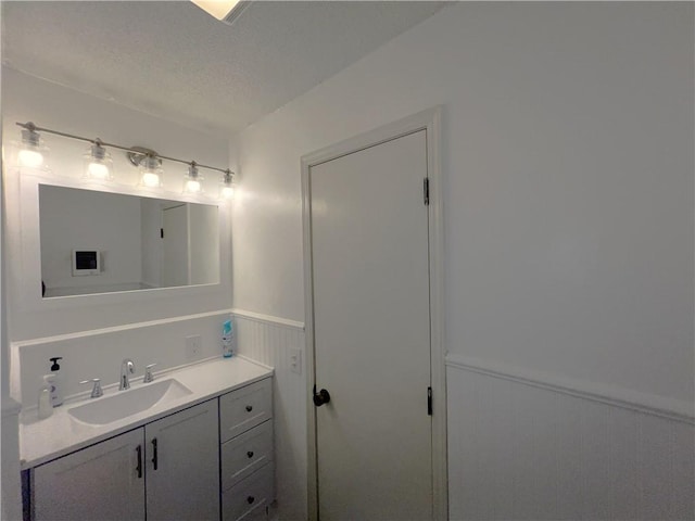 321 F Hwy, Anderson, MO 64831 - bathroom with wainscoting, vanity, and a textured ceiling