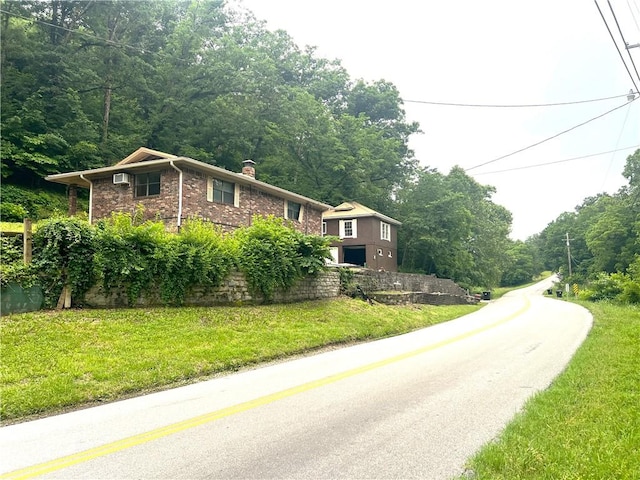 321 F Hwy, Anderson, MO 64831 - view of front facade featuring a chimney, a front lawn, and a view of trees
