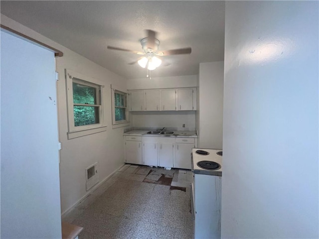 321 F Hwy, Anderson, MO 64831 - kitchen featuring white range with electric cooktop, ceiling fan, white cabinets, a sink, and baseboards