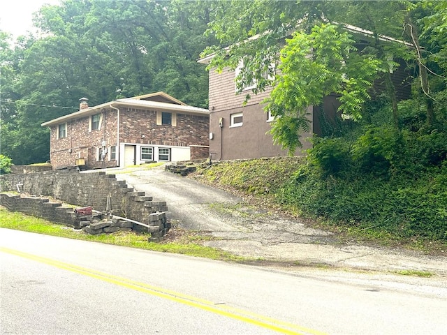 321 F Hwy, Anderson, MO 64831 - view of front of property with driveway, a chimney, and brick siding