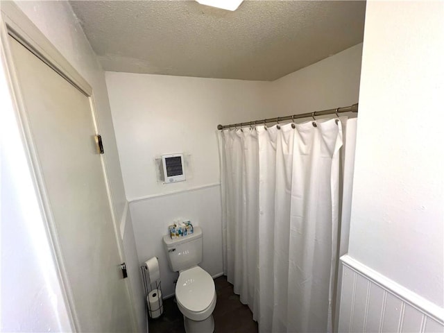 321 F Hwy, Anderson, MO 64831 - full bath with toilet, a textured ceiling, wainscoting, curtained shower, and heating unit
