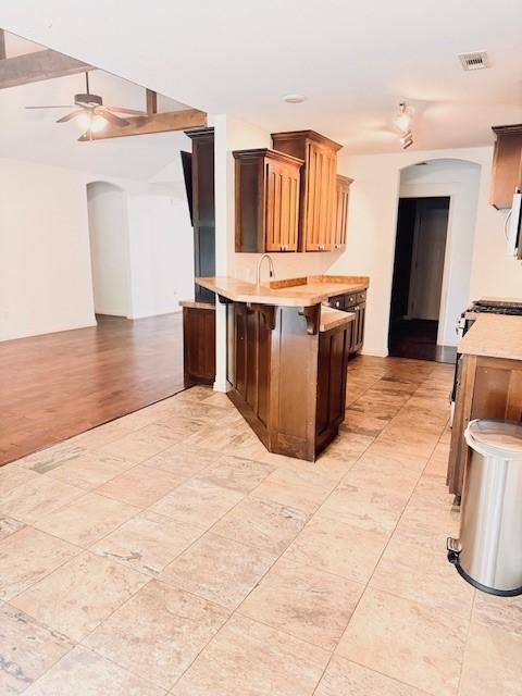 1117 Nemett Dr, Pea Ridge, AR 72751 - kitchen featuring arched walkways, light countertops, ceiling fan, a peninsula, and open floor plan