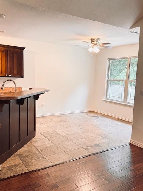1117 Nemett Dr, Pea Ridge, AR 72751 - kitchen featuring ceiling fan, a kitchen breakfast bar, baseboards, and a sink
