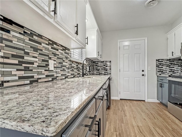 405 14th Pl, Rogers, AR 72756 - kitchen featuring a sink, stainless steel range, backsplash, white cabinetry, and light wood-type flooring