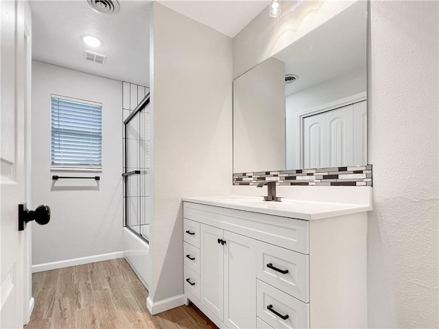 405 14th Pl, Rogers, AR 72756 - full bath featuring vanity, backsplash, wood finished floors, shower / bath combination with glass door, and baseboards