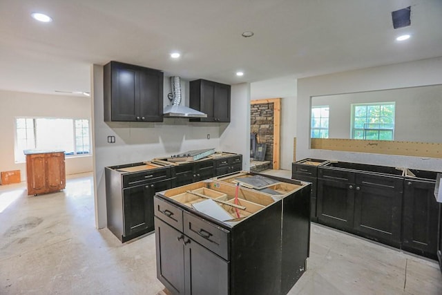 1732 Madison Unit 4316, Elkins, AR 72727 - kitchen featuring wall chimney exhaust hood, dark cabinetry, a center island, recessed lighting, and a fireplace
