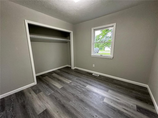154 Mc 7059, Flippin, AR 72634 - unfurnished bedroom featuring dark wood-type flooring, baseboards, a textured ceiling, and a closet