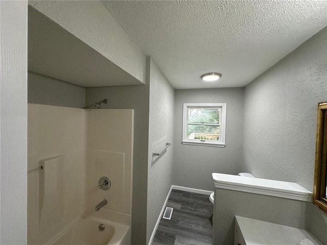 154 Mc 7059, Flippin, AR 72634 - bathroom featuring wood finished floors, toilet, bathtub / shower combination, a textured ceiling, and baseboards
