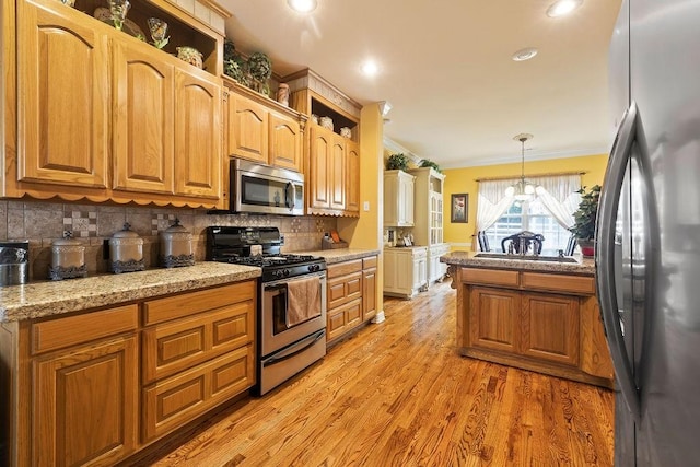 19537 Eastfork Ln, Gravette, AR 72736 - kitchen featuring stainless steel appliances, ornamental molding, tasteful backsplash, light wood-type flooring, and a chandelier