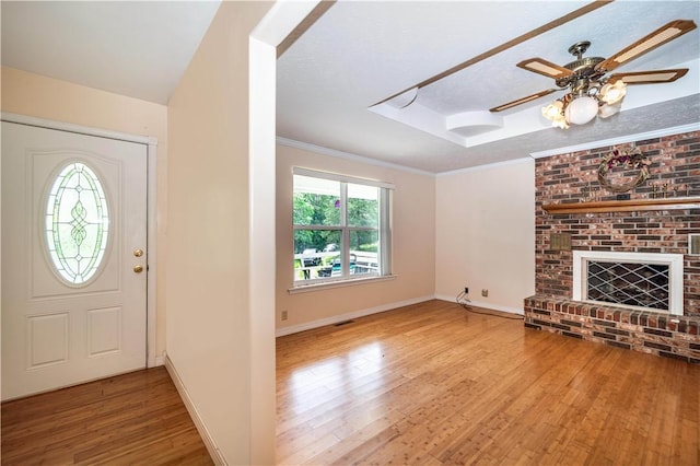 585 County Road 217, Berryville, AR 72616 - foyer entrance featuring wood finished floors, a tray ceiling, a fireplace, baseboards, and a skylight